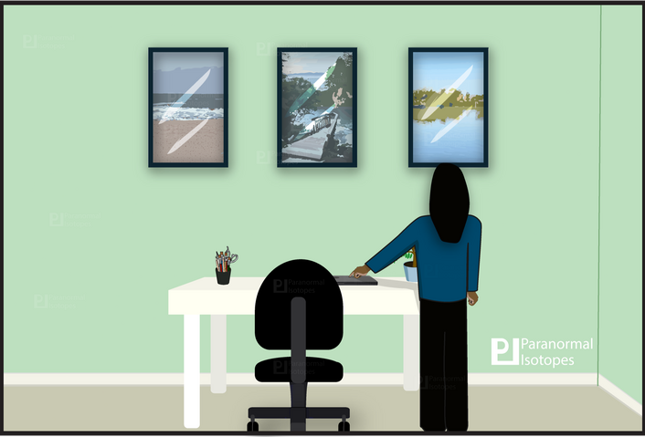 Image of a girl stands to the side her black office chair in the light green painted room. Facing the wall with three painting hung upon it. She's finished working on her dark grey laptop and uses one finger to close it.